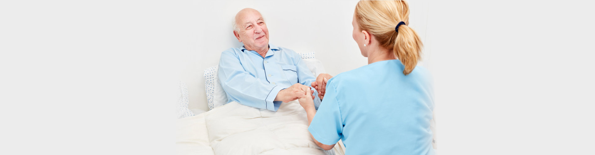 bedridden elderly talking to caregiver